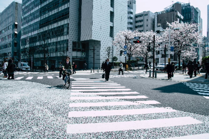 都市部の交差点を行き交う人々と街並みの風景